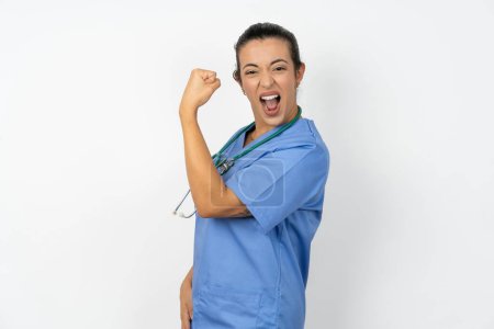 Téléchargez les photos : Profil vue de côté portrait médecin arabe femme en uniforme bleu célèbre la victoire - en image libre de droit