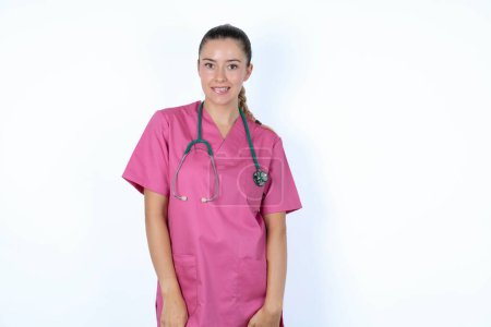 Photo for Caucasian woman doctor in pink uniform with stethoscope being nervous and scared biting lips looking camera with impatient expression, pensive. - Royalty Free Image