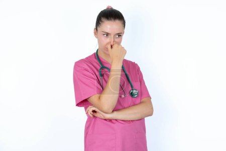 Foto de Caucásica médico femenino sosteniendo su nariz debido a un mal olor. - Imagen libre de derechos