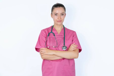 Foto de Imagen de la doctora caucásica enojada en uniforme rosa con cámara de aspecto estetoscopio. - Imagen libre de derechos