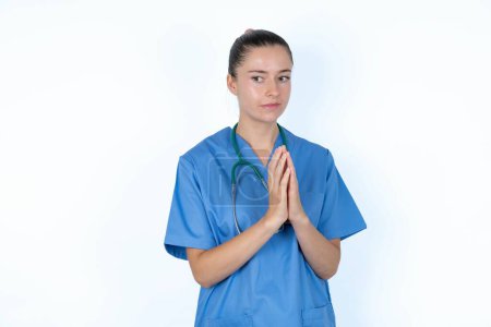 Photo for Caucasian female doctor  steepled fingers and looks mysterious aside has great evil plan in mind - Royalty Free Image