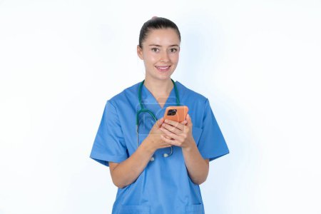 Photo for Caucasian female doctor using mobile phone, typing sms message - Royalty Free Image