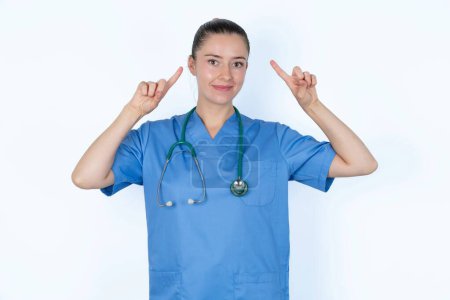 Photo for Cheerful caucasian woman doctor in  uniform with stethoscope demonstrating hairdo - Royalty Free Image