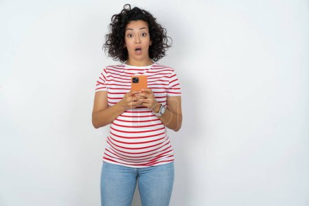 Foto de Embarazada mujer embarazada abre boca sostener teléfono lectura anuncio increíble grandes precios de las compras - Imagen libre de derechos