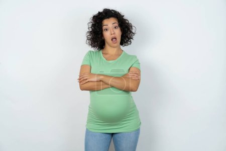 Photo for Shocked embarrassed pregnant woman keeps mouth widely opened. Hears unbelievable novelty stares in stupor - Royalty Free Image
