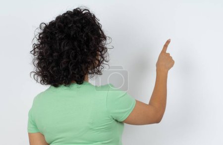 Photo for Pregnant woman pointing to object on copy space, rear view. Turn your back - Royalty Free Image