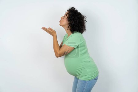 Foto de Perfil vista lateral de mujer embarazada atractiva enviando beso de aire - Imagen libre de derechos