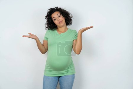 Téléchargez les photos : Insouciante jolie femme enceinte haussant les épaules, concept oops - en image libre de droit