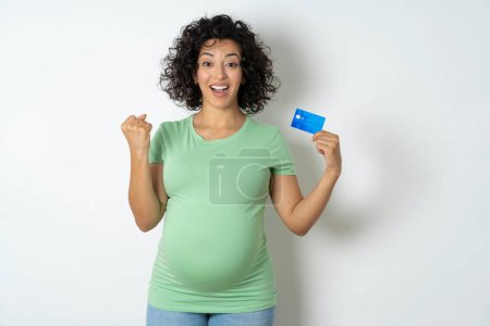 Foto de Foto de mujer embarazada afortunada impresionada sosteniendo tarjeta de crédito. - Imagen libre de derechos