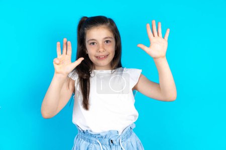 Téléchargez les photos : Belle fille enfant caucasien debout sur fond bleu studio montrant et pointant vers le haut avec les doigts numéro neuf tout en souriant confiant et heureux. - en image libre de droit