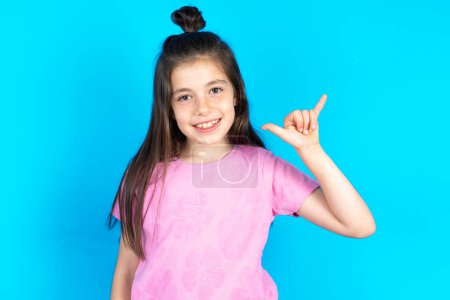 Photo for Kid showing up number six Liu with fingers gesture in sign Chinese language. Beautiful caucasian little girl posing over blue studio background - Royalty Free Image
