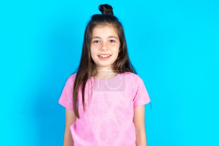 Photo for Kid with nice smile. Positive emotions concept. Beautiful caucasian little girl posing over blue studio background - Royalty Free Image