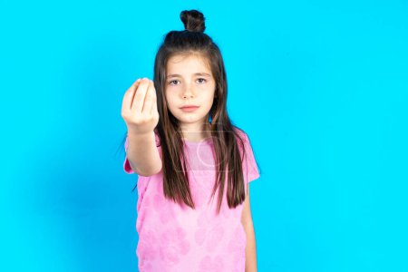 Téléchargez les photos : Enfant Faire geste italien avec la main et les doigts expression confiante. Belle petite fille caucasienne posant sur fond bleu studio - en image libre de droit