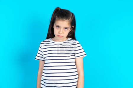 Photo for Kid depressed and worried, crying angry and afraid. Sad expression. Beautiful caucasian girl standing over blue studio background - Royalty Free Image