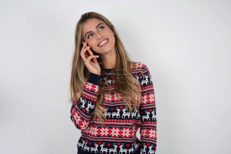Téléchargez les photos : Femme caucasienne drôle portant chandail de Noël rit heureusement, a la conversation téléphonique, étant amusé par un ami, ferme les yeux. - en image libre de droit