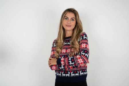 Téléchargez les photos : Femme caucasienne confiante portant un pull de Noël avec les bras croisés regardant vers la caméra - en image libre de droit
