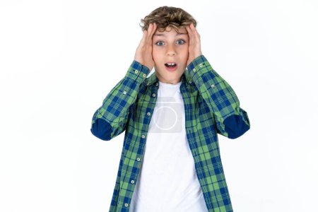 Photo for Handsome caucasian teenager boy on white studio background with scared expression, keeps hands on head, jaw dropped, has terrific expression. Omg concept - Royalty Free Image