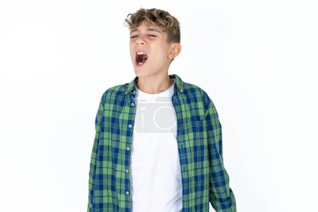 Foto de Guapo caucásico adolescente chico en blanco estudio fondo enojado y loco gritando frustrado y furioso, gritando con ira. Rabia y concepto agresivo. - Imagen libre de derechos