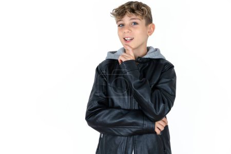 Photo for Handsome caucasian teenager boy on white studio background laughs happily keeps hand on chin expresses positive emotions smiles broadly has carefree expression - Royalty Free Image