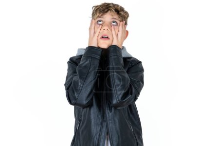 Photo for Handsome caucasian teenager boy on white studio background keeps hands on cheeks has bored displeased expression. Stressed hopeless model - Royalty Free Image