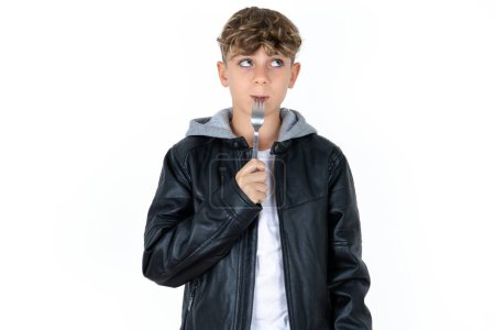 Photo for Photo of dreamy handsome caucasian teenager boy on white studio background lick fork look empty space - Royalty Free Image