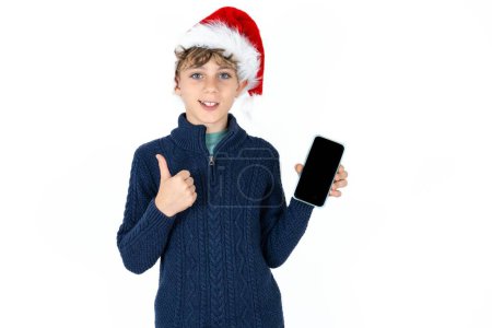 Foto de Guapo caucásico adolescente chico en blanco estudio fondo Mostrar pantalla en blanco smartphone, pulgar hacia arriba recomendar nueva aplicación - Imagen libre de derechos