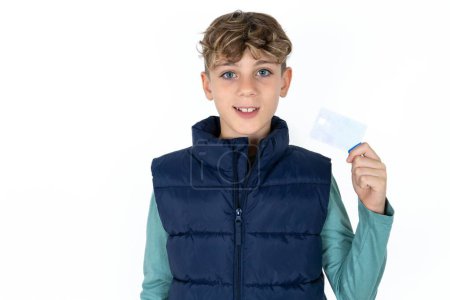 Photo for Photo of happy cheerful smiling positive handsome caucasian teenager boy on white studio background recommend credit card - Royalty Free Image