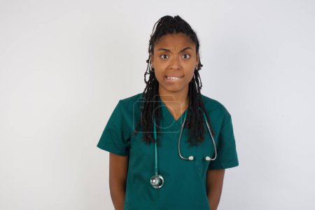 Photo for Beautiful young doctor woman being nervous and scared biting lips looking camera with impatient expression, pensive, wears medical uniform isolated over background. - Royalty Free Image