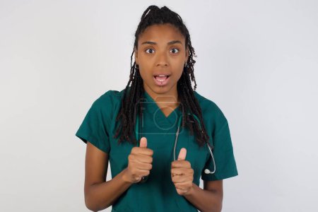 Photo for Human face expressions and emotions. Portrait of young doctor woman looking panic, holding her hands near her face, with mouth wide open. Surprise and shock. - Royalty Free Image