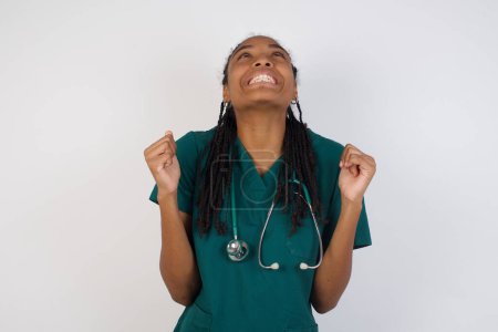 Photo for Excited young doctor woman raising her fists with great happiness having good mood, having success being glad to achieve her goals. Victory and triumph concept. - Royalty Free Image