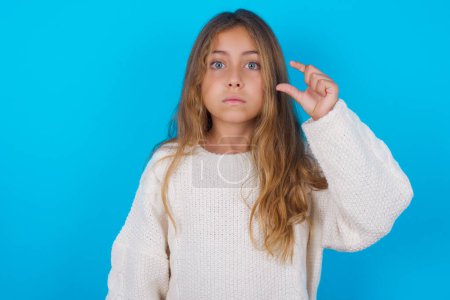 Foto de Bastante adolescente chica monederos labio y gestos con la mano, muestra algo muy poco. - Imagen libre de derechos