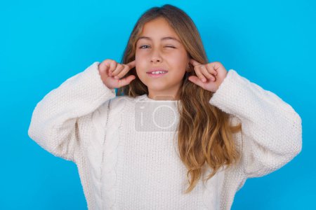 Foto de Feliz chica adolescente bonita ignora la música fuerte y tapones oídos con los dedos pide apagar el sonido - Imagen libre de derechos
