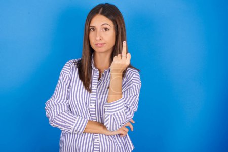 Photo for Beautiful young woman shows middle finger bad sign asks not to bother. Provocation and rude attitude. - Royalty Free Image