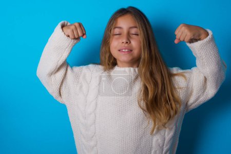 Photo for Strong powerful pretty teen girl toothy smile, raises arms and shows biceps. Look at my muscles! - Royalty Free Image
