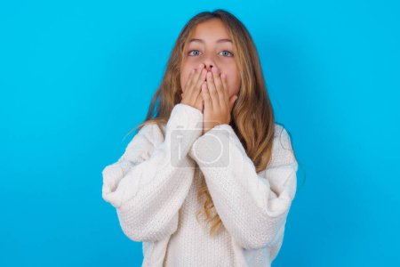 Photo for Pretty teen girl keeps hands on mouth, looks with eyes full of disbelief, being puzzled with amount of work - Royalty Free Image