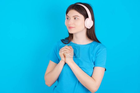 Photo for MODEL wears stereo headphones listening to music concentrated and looking aside with interest. - Royalty Free Image