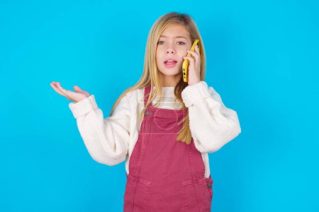 Photo for Pretty teen girl talking on the phone stressed with hand on face, shocked with shame and surprise face, angry and frustrated. Fear and upset for mistake. - Royalty Free Image