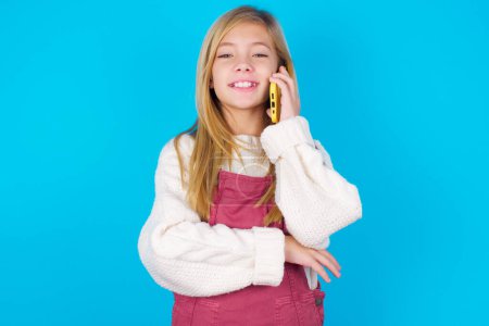 Portrait of a smiling pretty teen girl talking on mobile phone. Business, confidence and communication concept.