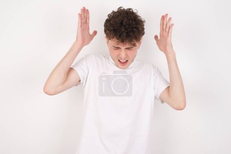 Photo for Handsome young man goes crazy as head goes around feels stressed because of horrible situation - Royalty Free Image