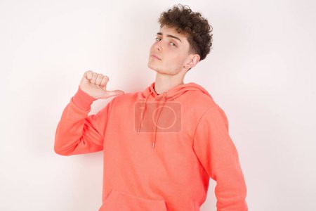 Photo for Closeup of cheerful handsome young man looks joyful, satisfied and confident, points at himself with thumb. - Royalty Free Image