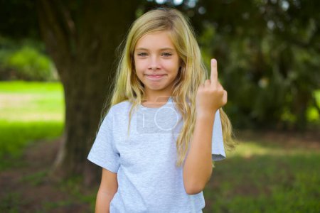 Foto de Chica bonita muestra dedo medio mala señal pide que no se moleste. Provocación y actitud grosera. - Imagen libre de derechos