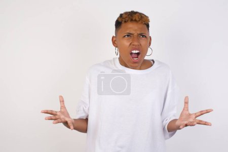 Photo for Screaming, hate, rage. Crying emotional angry young african-american woman wearing white t-shirt screaming, Human emotions concept. - Royalty Free Image