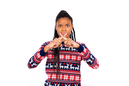 Téléchargez les photos : Femme afro-américaine portant un pull de Noël contre un mur blanc a rejet expression de colère en croisant les doigts faisant signe négatif. - en image libre de droit