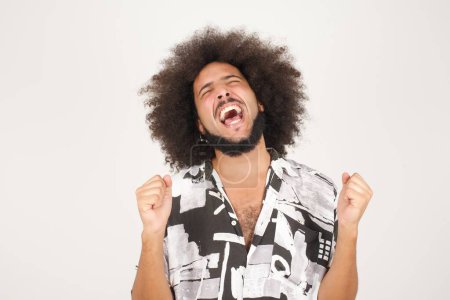 Téléchargez les photos : Portrait de beau jeune homme de race mixte expressif aux cheveux bouclés isolé sur blanc célébrant le succès - en image libre de droit