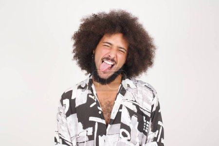 Téléchargez les photos : Portrait de beau jeune homme de race mixte expressif aux cheveux bouclés isolé sur grimacage blanc à la caméra - en image libre de droit