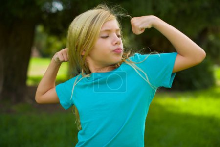 Photo for Pretty girl showing muscles in park - Royalty Free Image