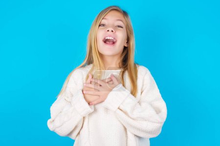 Photo for Happy smiling pretty teen girl has hands on chest near heart. Human emotions, real feelings and facial expression concept. - Royalty Free Image