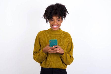 Téléchargez les photos : Souriant jeune femme amicale et heureuse tenant téléphone mobile prenant selfie dans le miroir. - en image libre de droit