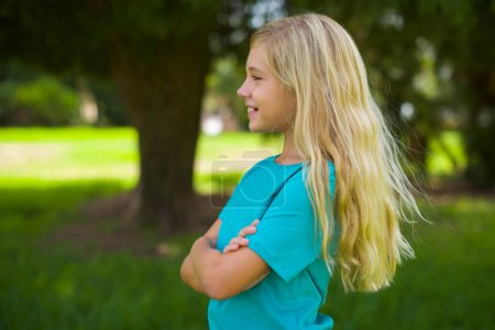 Photo for Pretty girl with crossed arms looking at side in park - Royalty Free Image