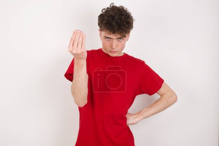 Foto de What the hell are you talking about. Shot of frustrated handsome young man over white background gesturing with raised hand doing Italian gesture, frowning, being displeased and confused with dumb question. - Imagen libre de derechos